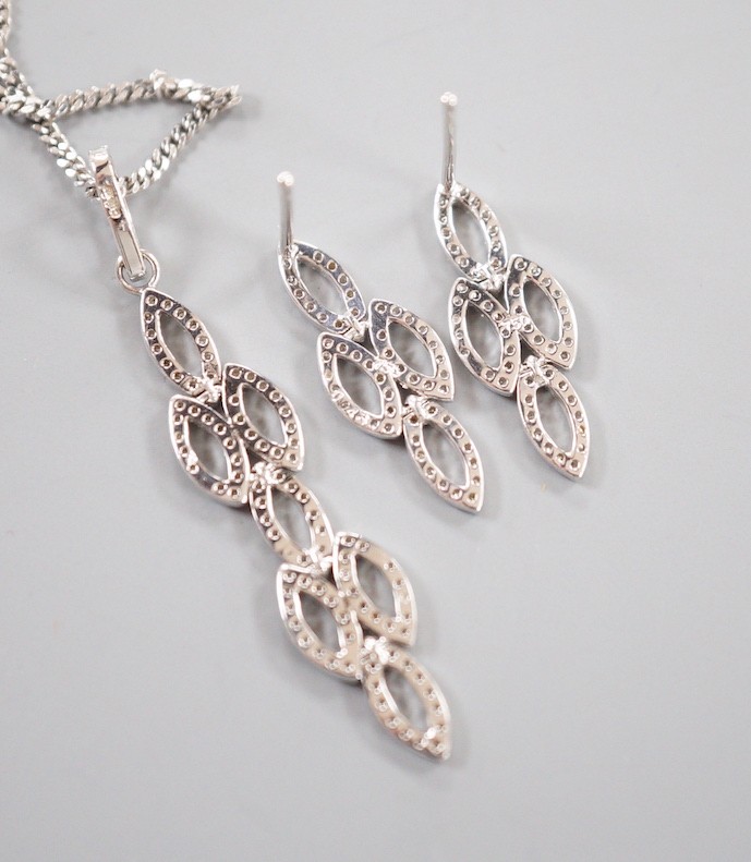 A modern 18ct white gold and diamond chip set septuple oval cluster pendant, overall 42mm, on an 18ct white gold fine link chain, 39cm and a pair of matching earrings, 21mm, gross weight 7.4 grams.